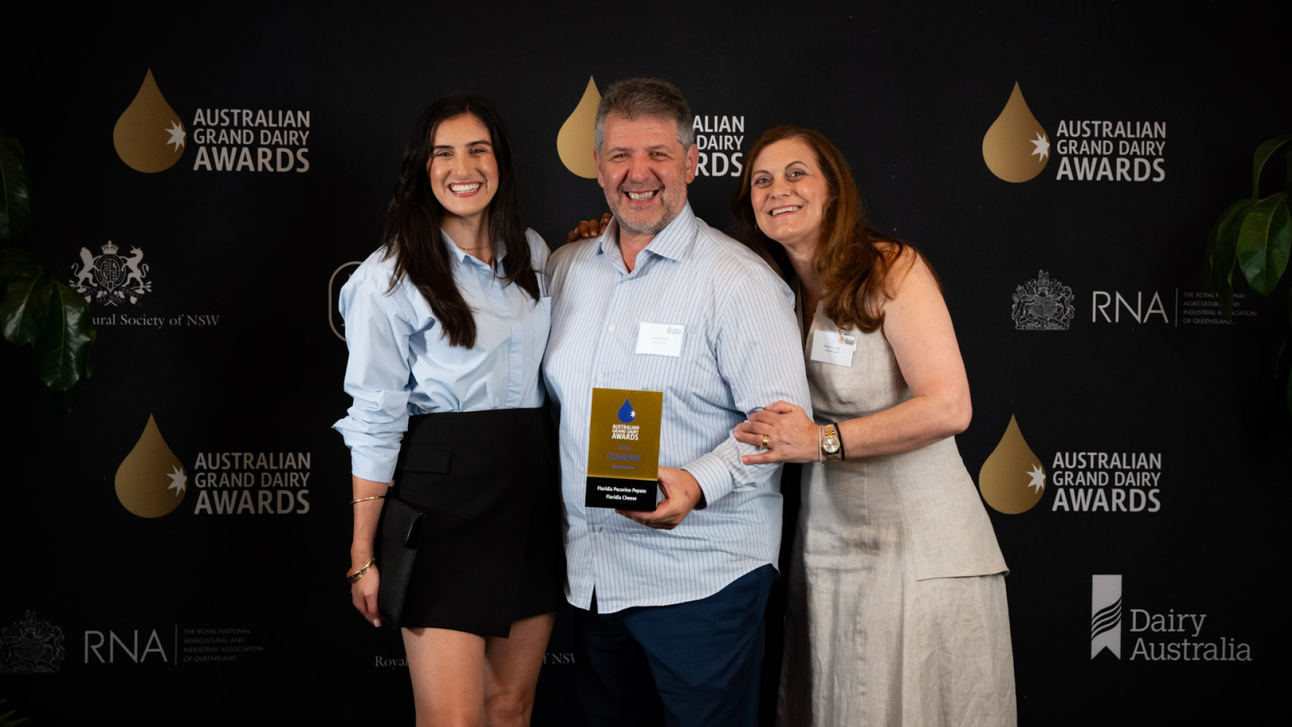 Three award winners are posing with their AGDA trophy.