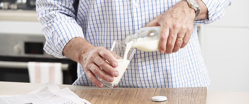 person pouring milk into a glass