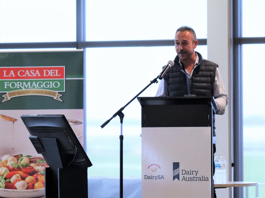 A presenter is speaking at conference program in front of an audience.