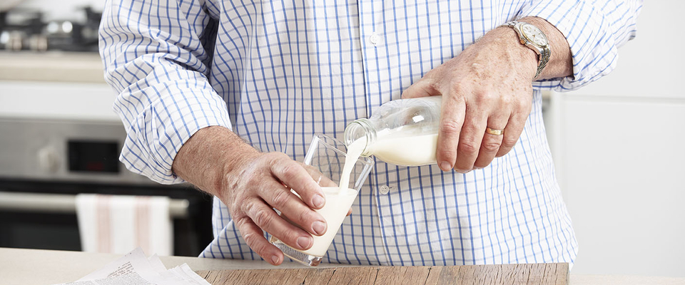 person pouring milk into a glass